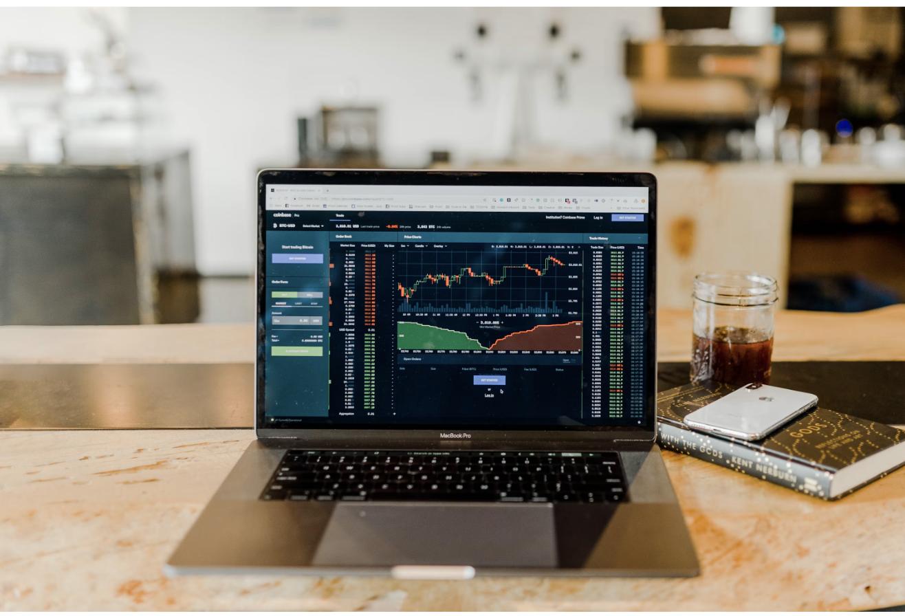 Laptop displaying a real-time trading dashboard, representing how REIT shares are bought and sold on public stock exchanges